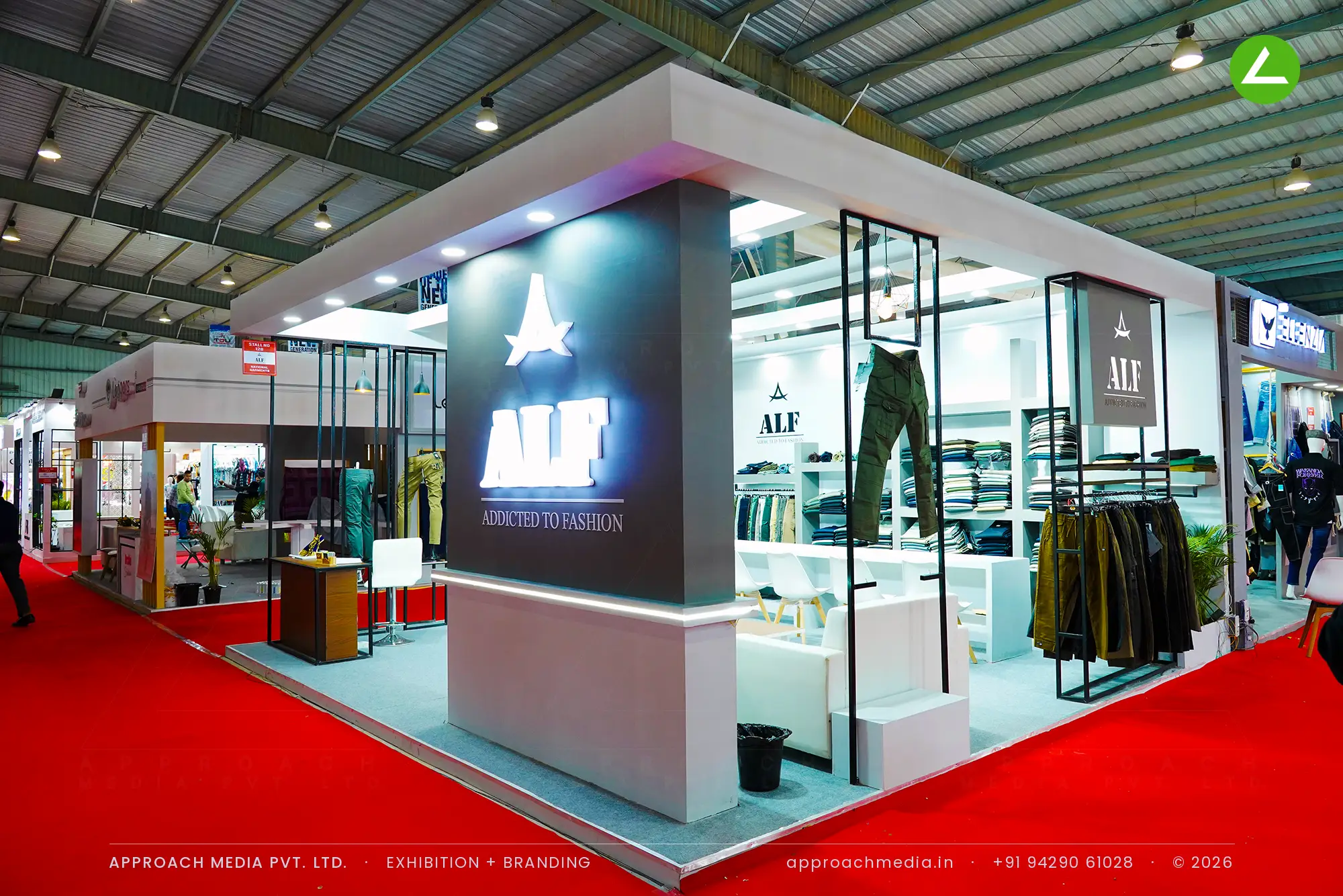 ALF exhibition stall design at GGMA Garment Fair Gandhinagar with a backlit star logo pylon and black garment rail frames