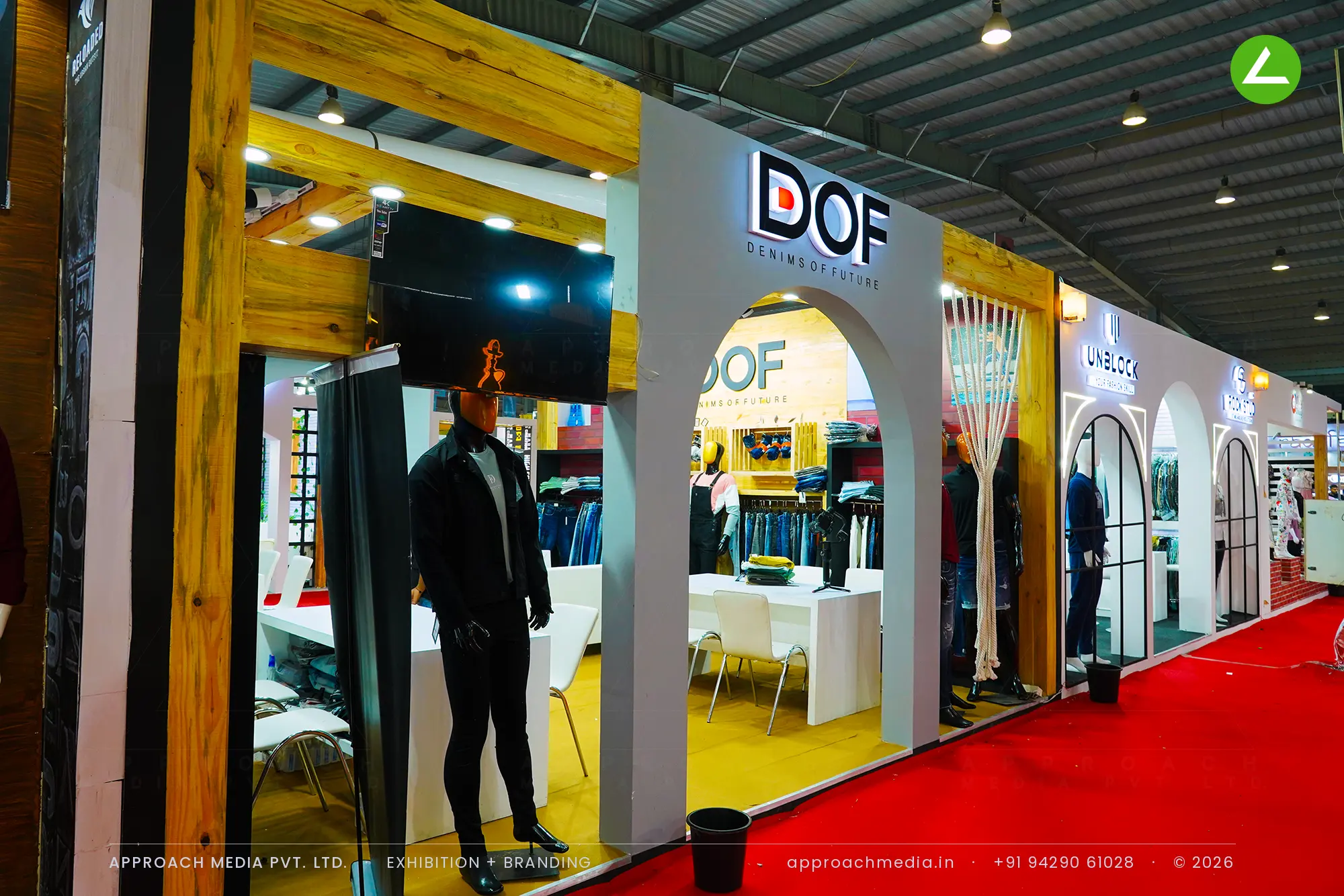 DOF exhibition stall design at GGMA Garment Fair Gandhinagar with grey arched openings, timber beams and denim rails inside