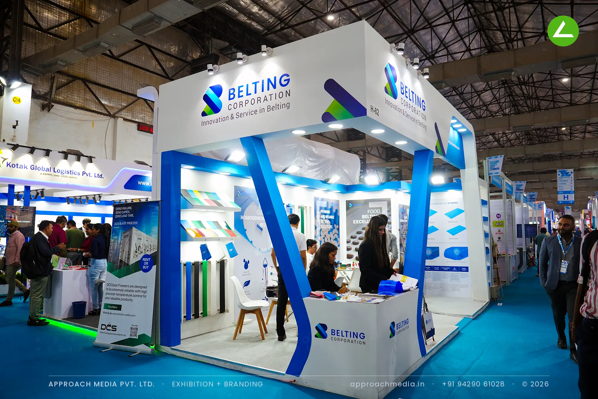 Blue tapered columns frame the opening of Belting Corporation's white stand, with conveyor belt samples on the back wall.