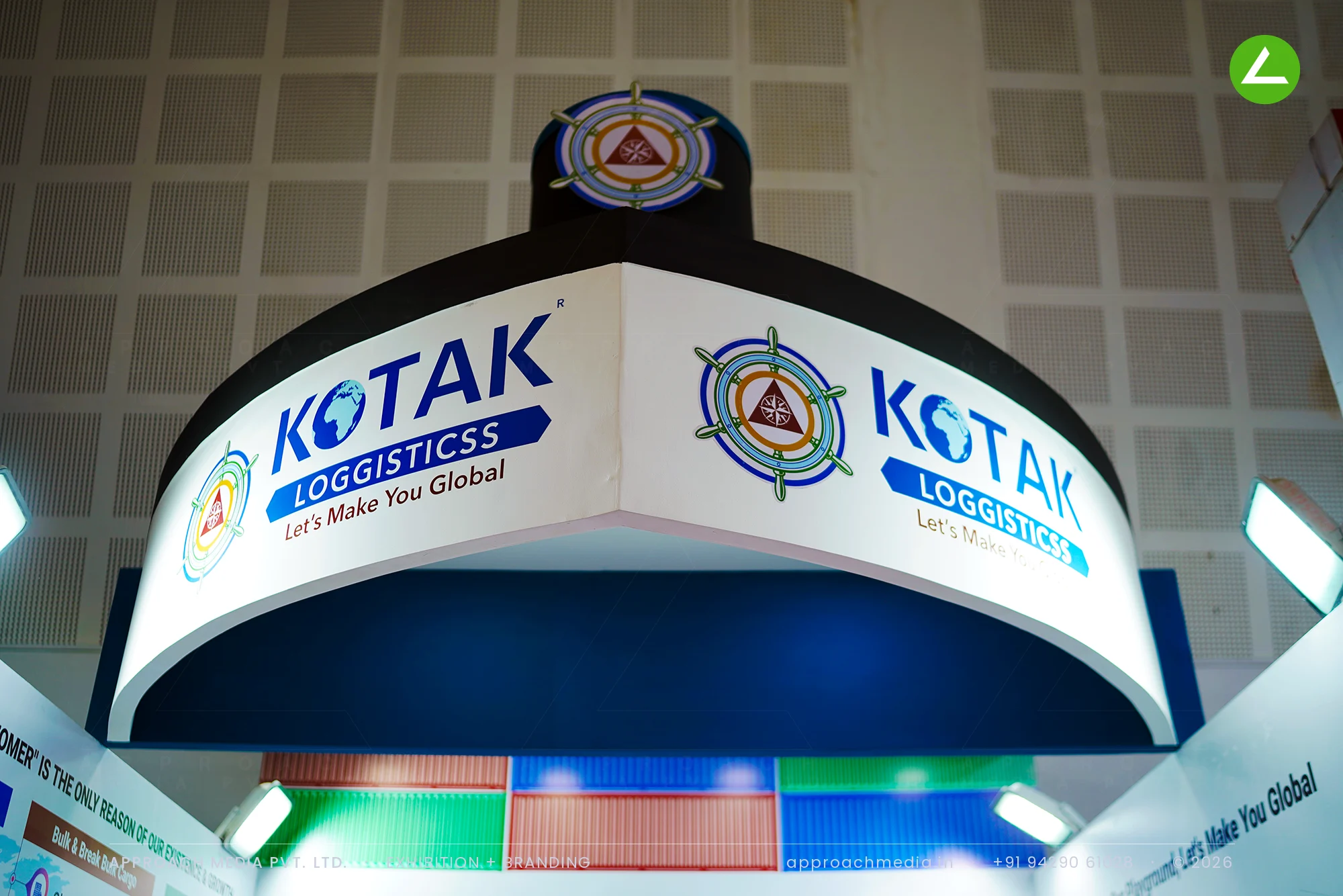 Kotak Loggisticss exhibition stall design at BNI Symposium Gandhinagar, curved crown fascia with a lit ship's wheel roundel