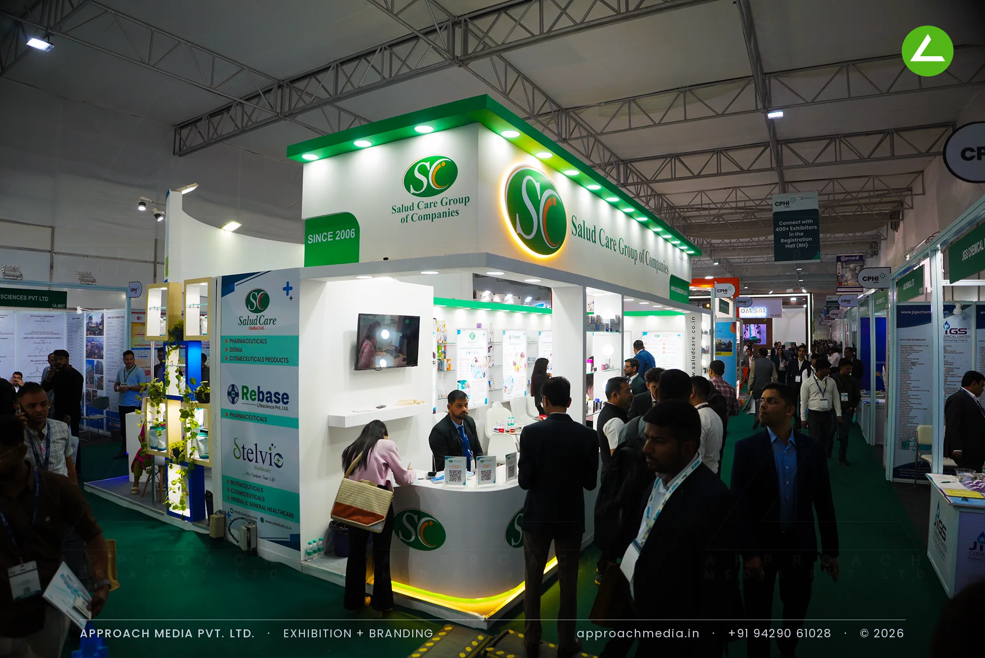 Salud Care exhibition stall design at CPHI Greater Noida with green cove-lit fascia and lit glass product shelves