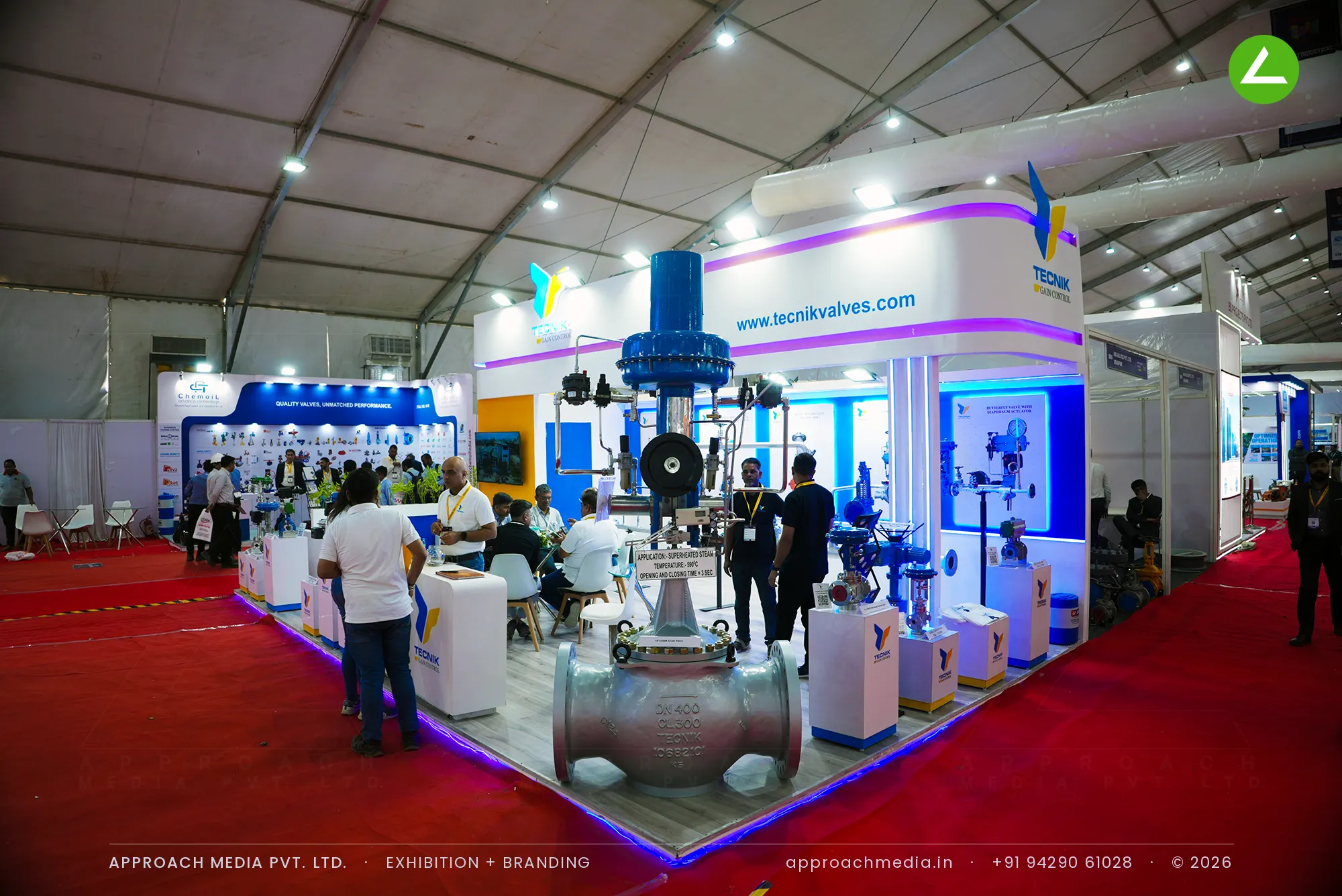 Tecnik exhibition stall design at Dahej Industrial Expo Dahej with magenta LED cove and control valves on white plinths