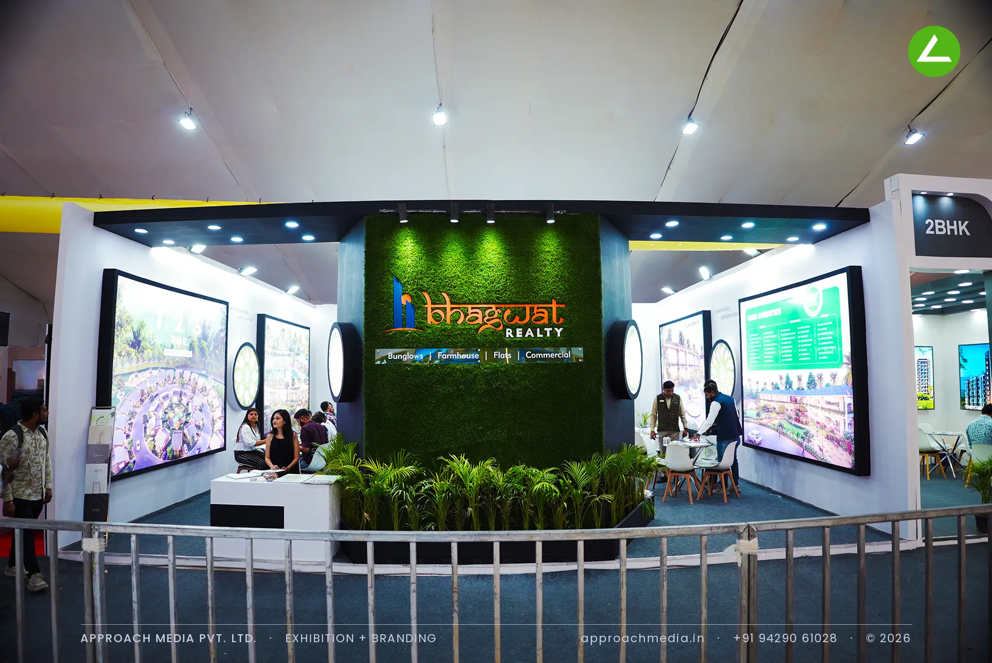 Bhagwat Realty exhibition stall design at Divya Bhaskar Property Show Vastral Ahmedabad with turf brand wall and lit renders