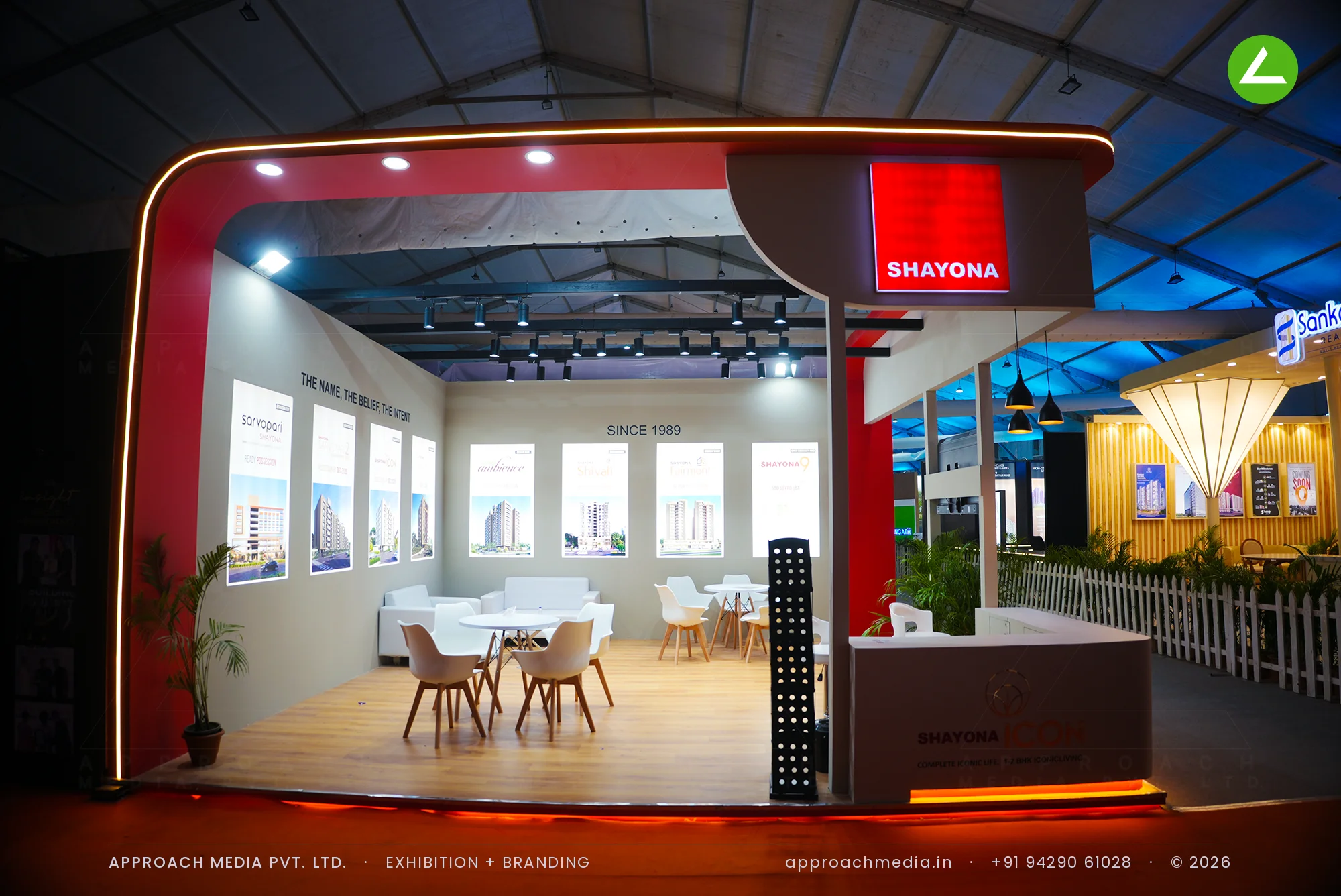 Shayona red arch exhibition stall design at NAREDCO Property Expo Ahmedabad with backlit project panel wall