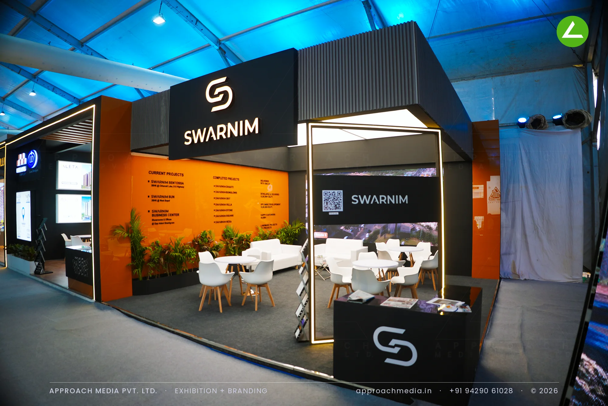 Swarnim orange and charcoal exhibition stall design at NAREDCO Property Expo Ahmedabad with a backlit fabric ceiling