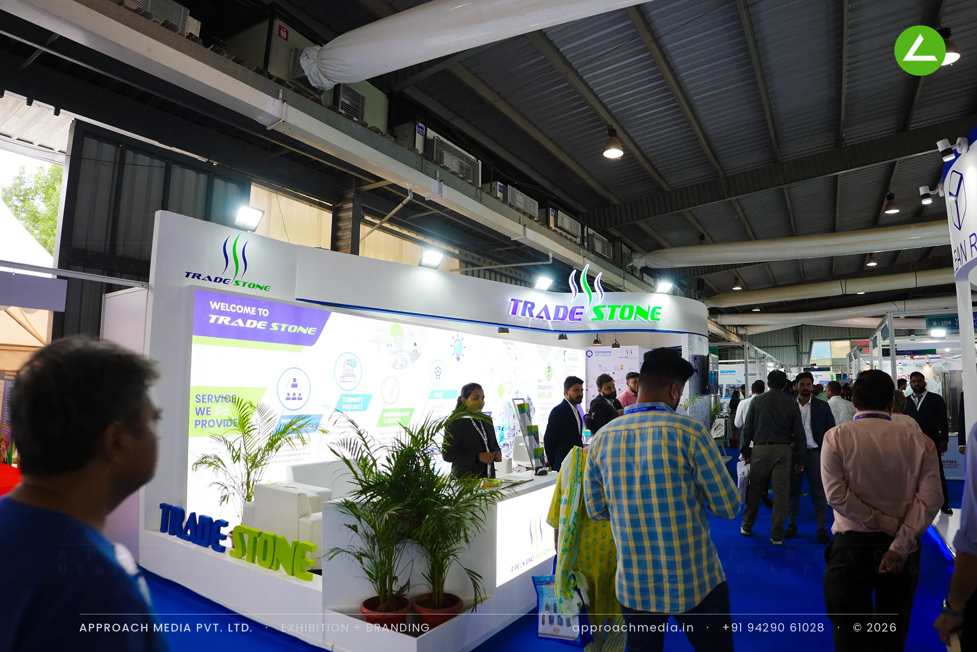 Trade Stone stall at Pharmatech Expo Gandhinagar with a lit fascia sign box and a printed services infographic wall