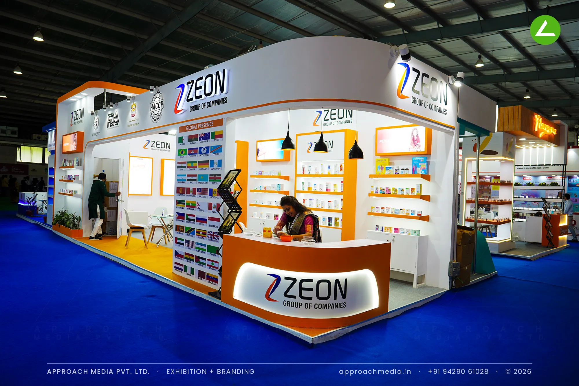 Zeon Group exhibition stall design at Pharmatech Expo Gandhinagar with curved orange header and shelved pharmaceutical packs