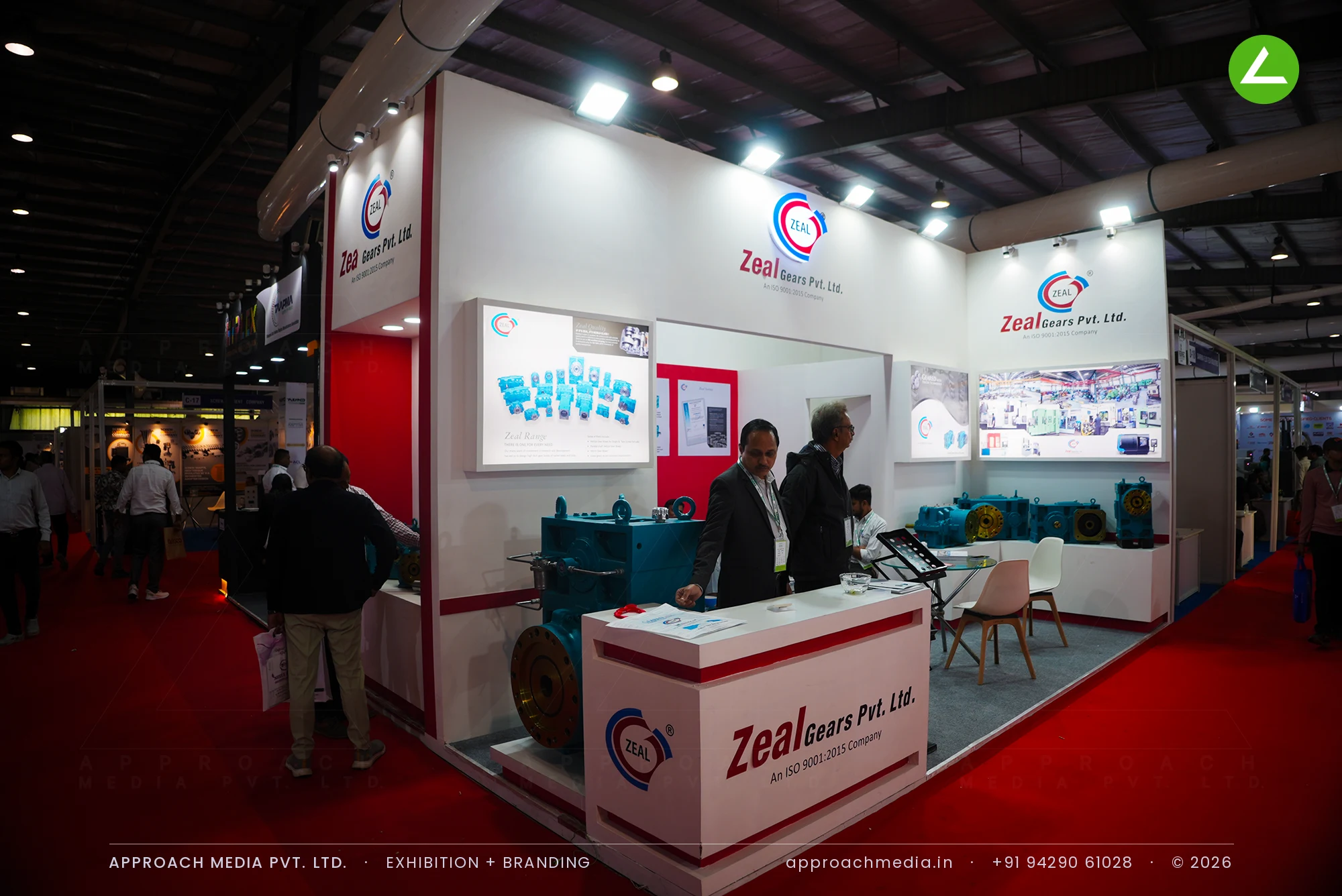Zeal Gears stall at Plexpo India Gandhinagar with gear units raised on white plinths against a red centre panel