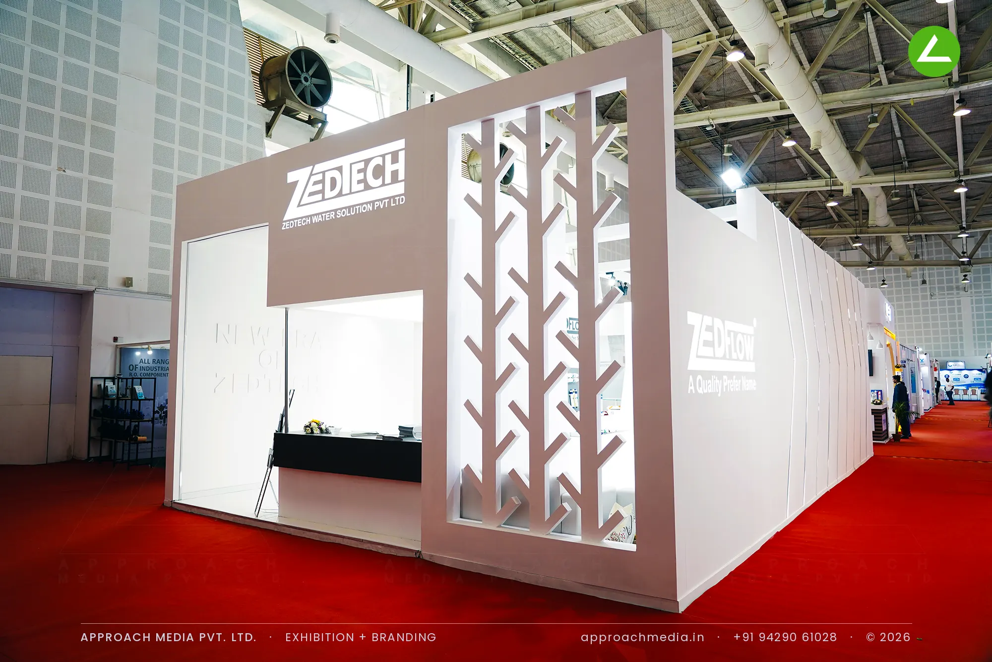 Zedtech's faceted white stall at WAPTAG Water Expo, with a mocha portal cut as a branch-pattern jali screen