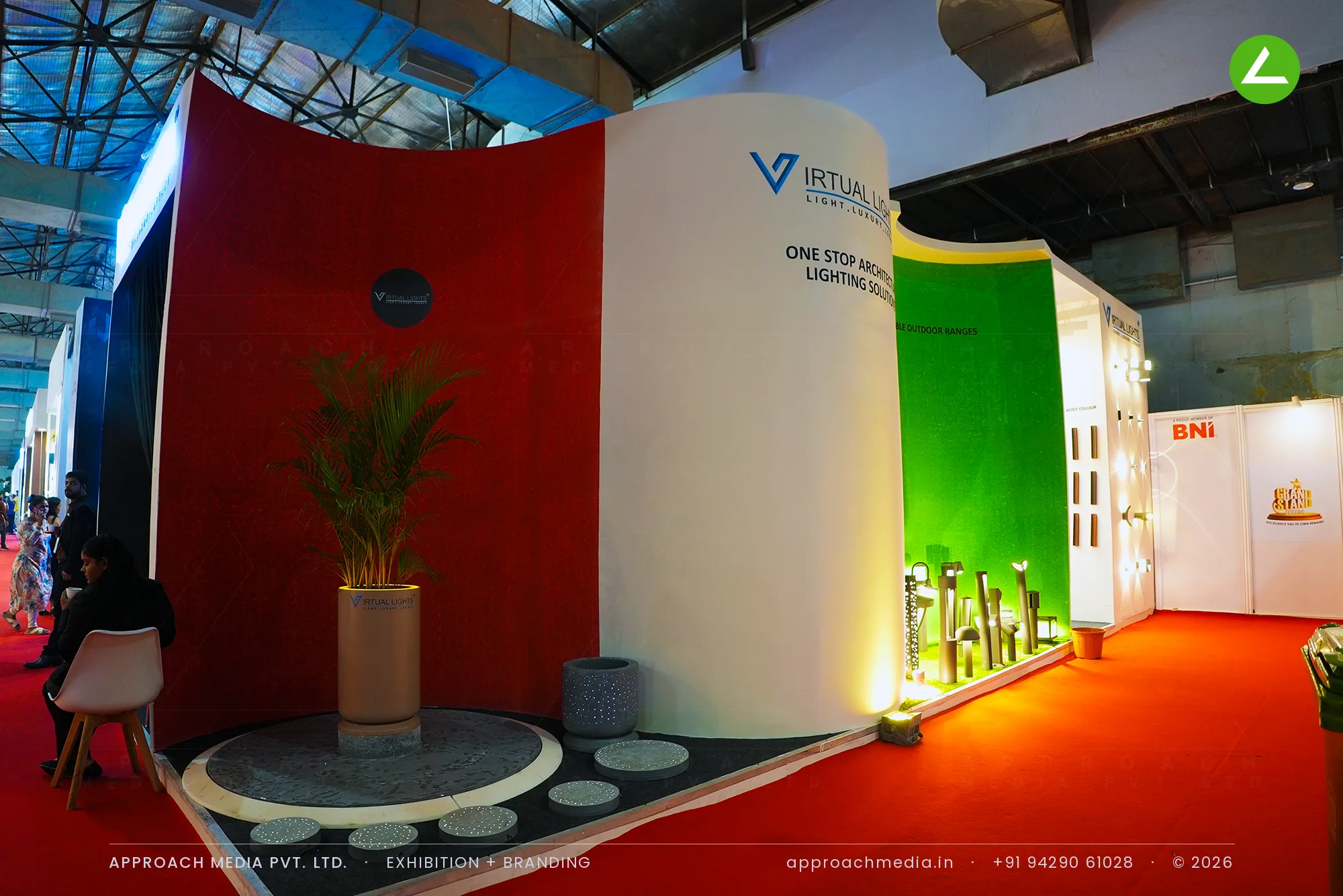 Virtual Lights' red, white and green curved walls at ACETECH Mumbai, with outdoor bollards on a lit grass plinth