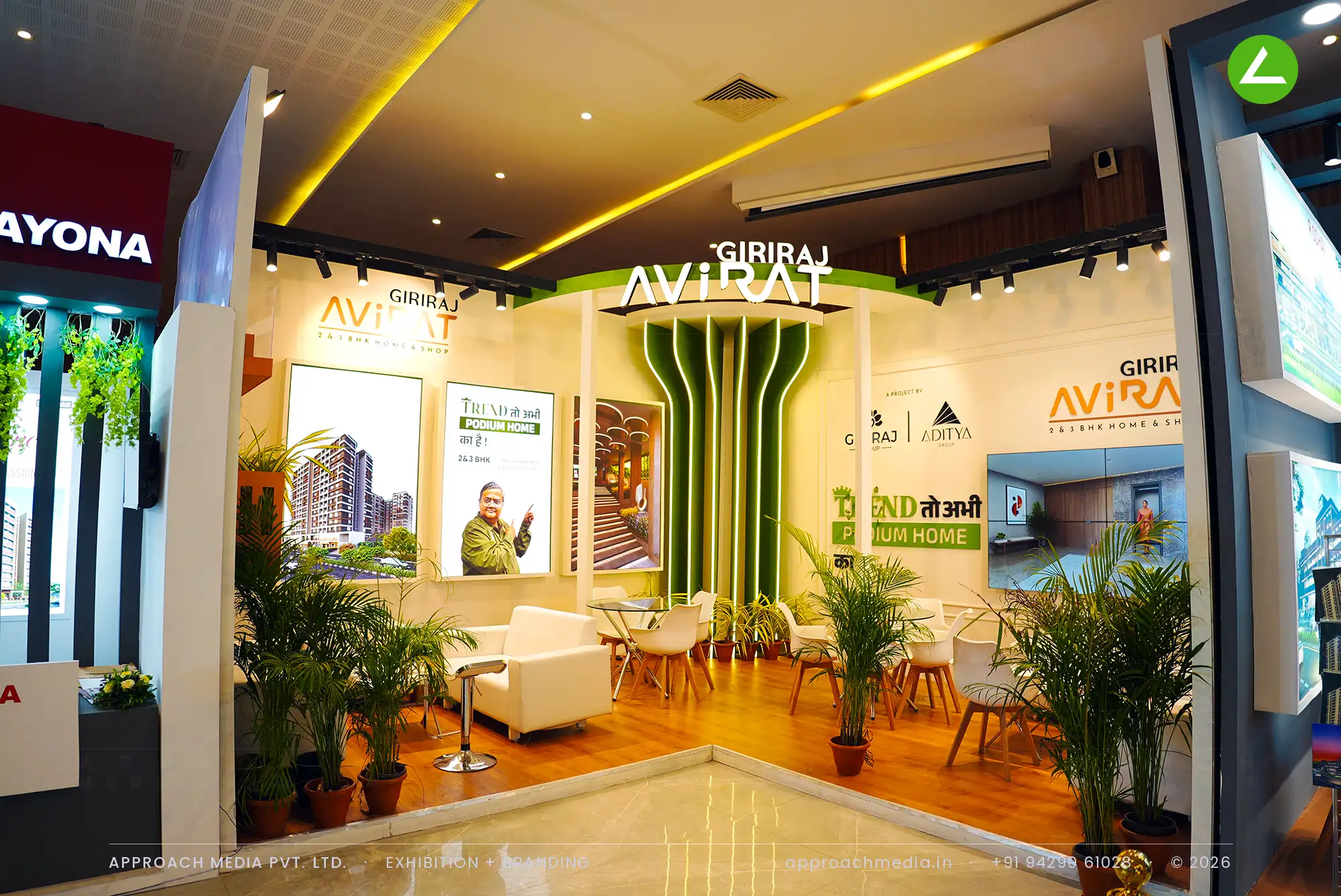 Giriraj Avirat's splayed moss-green fluted column between cream walls of backlit tower posters, on honey wood planks