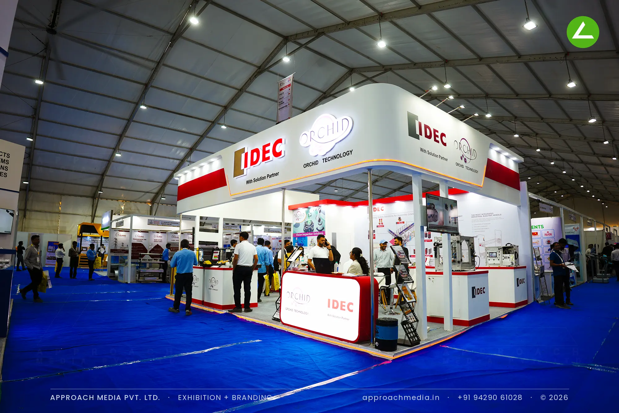 IDEC exhibition stall design at Dahej Industrial Expo Bharuch with a red-banded white canopy over demo plinths