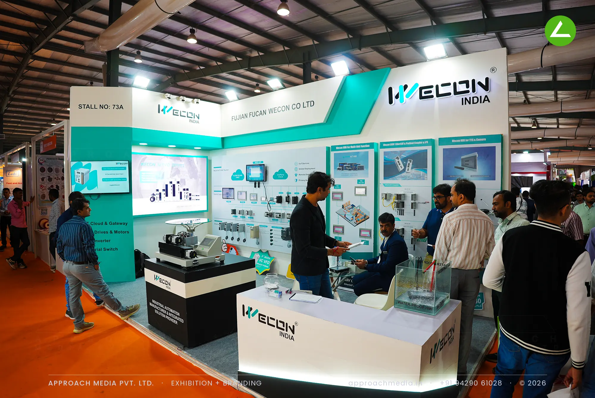 Wecon India exhibition stall design at EngiMach Gandhinagar with a teal and white live automation wall and video screen