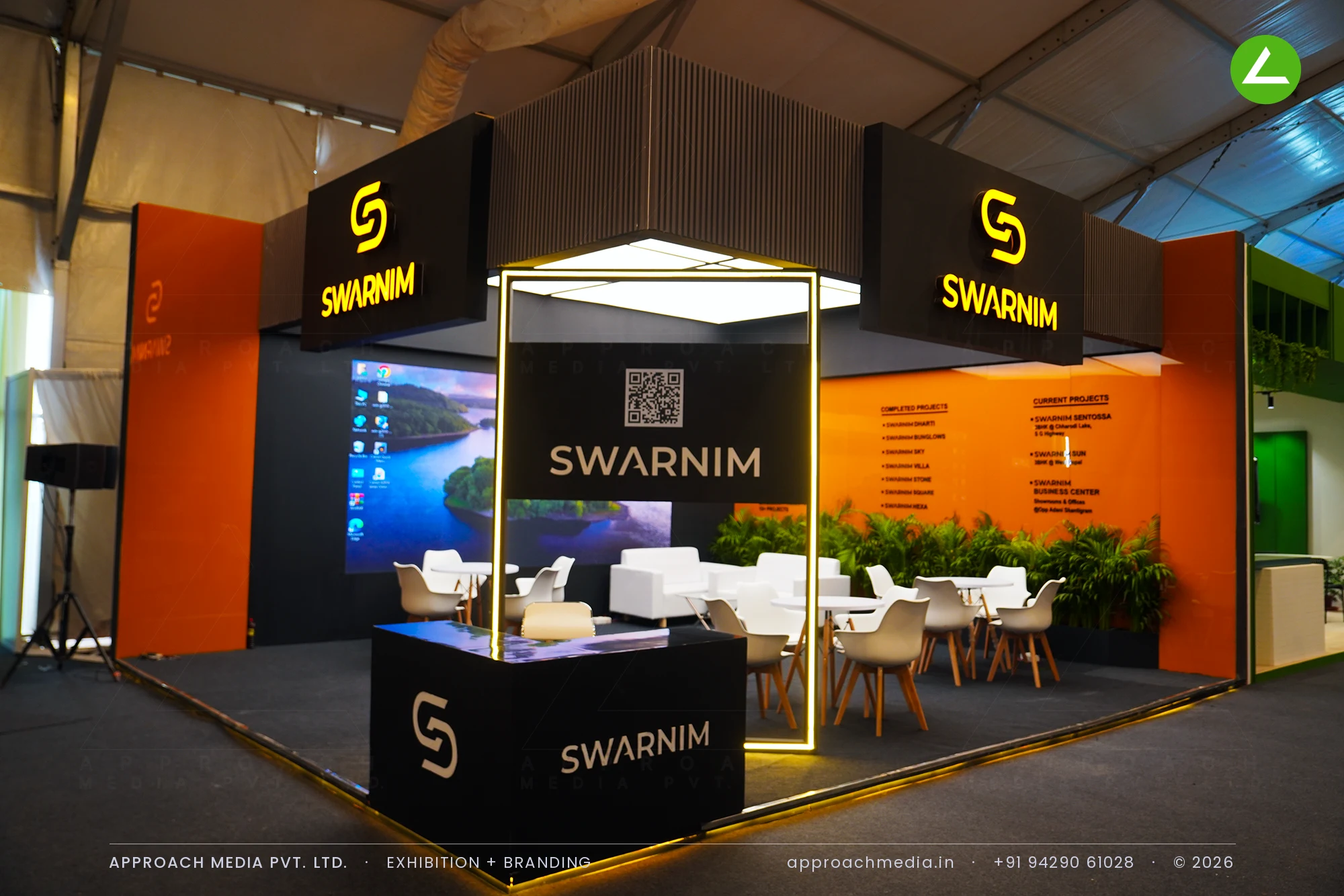 Swarnim's stall at the GIHED Property Show Ahmedabad, with twin lit black fascias over the corner and a large LED screen