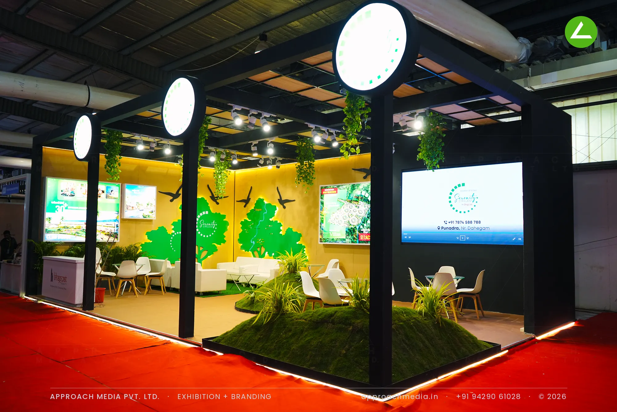 Serenity Circles exhibition stall design at GPBS Gandhinagar with a black pergola, backlit tree walls and a grass mound