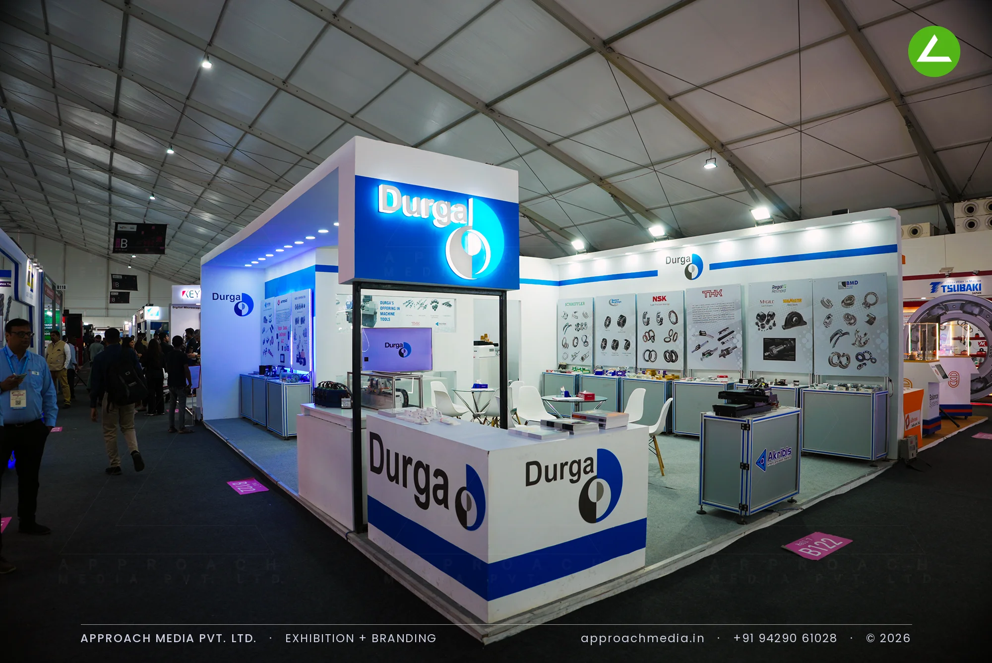 Durga exhibition stall design at IMTEX Bengaluru with backlit blue logo tower and glass component cabinets