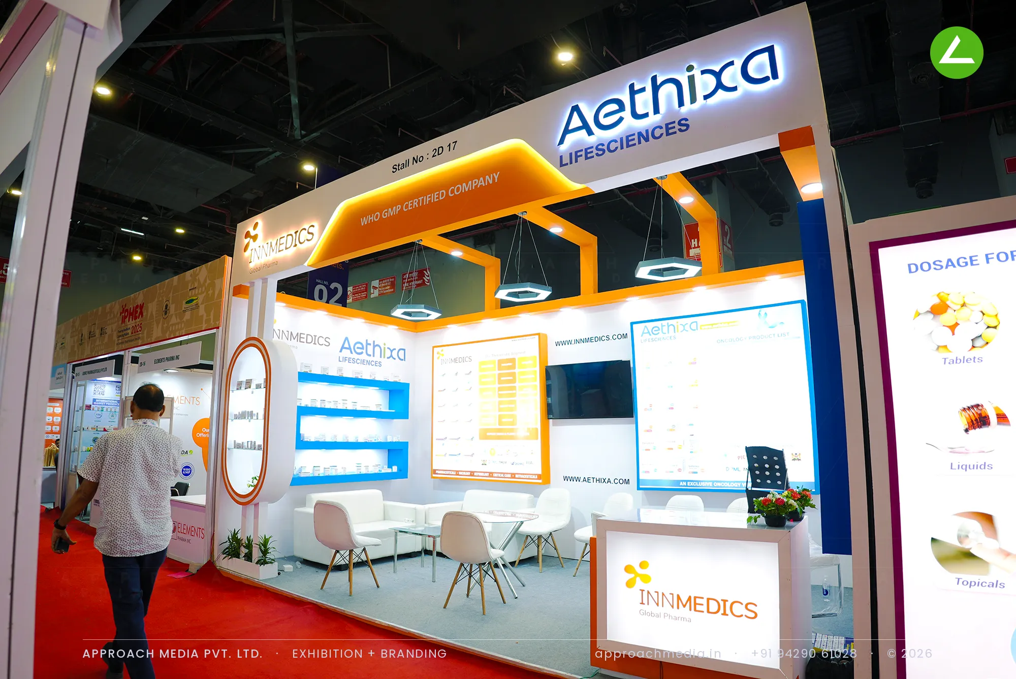 Aethixa Lifesciences exhibition stall design at iPHEX New Delhi with orange beam framing and backlit product shelves