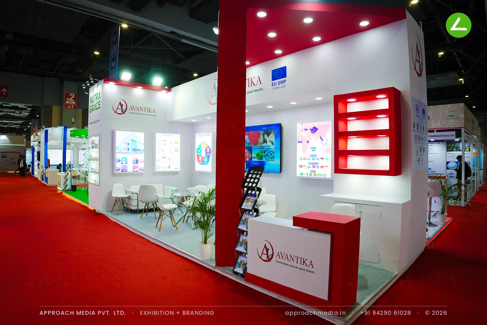 Avantika exhibition stall design at iPHEX New Delhi with an angled crimson canopy and lit red display niches
