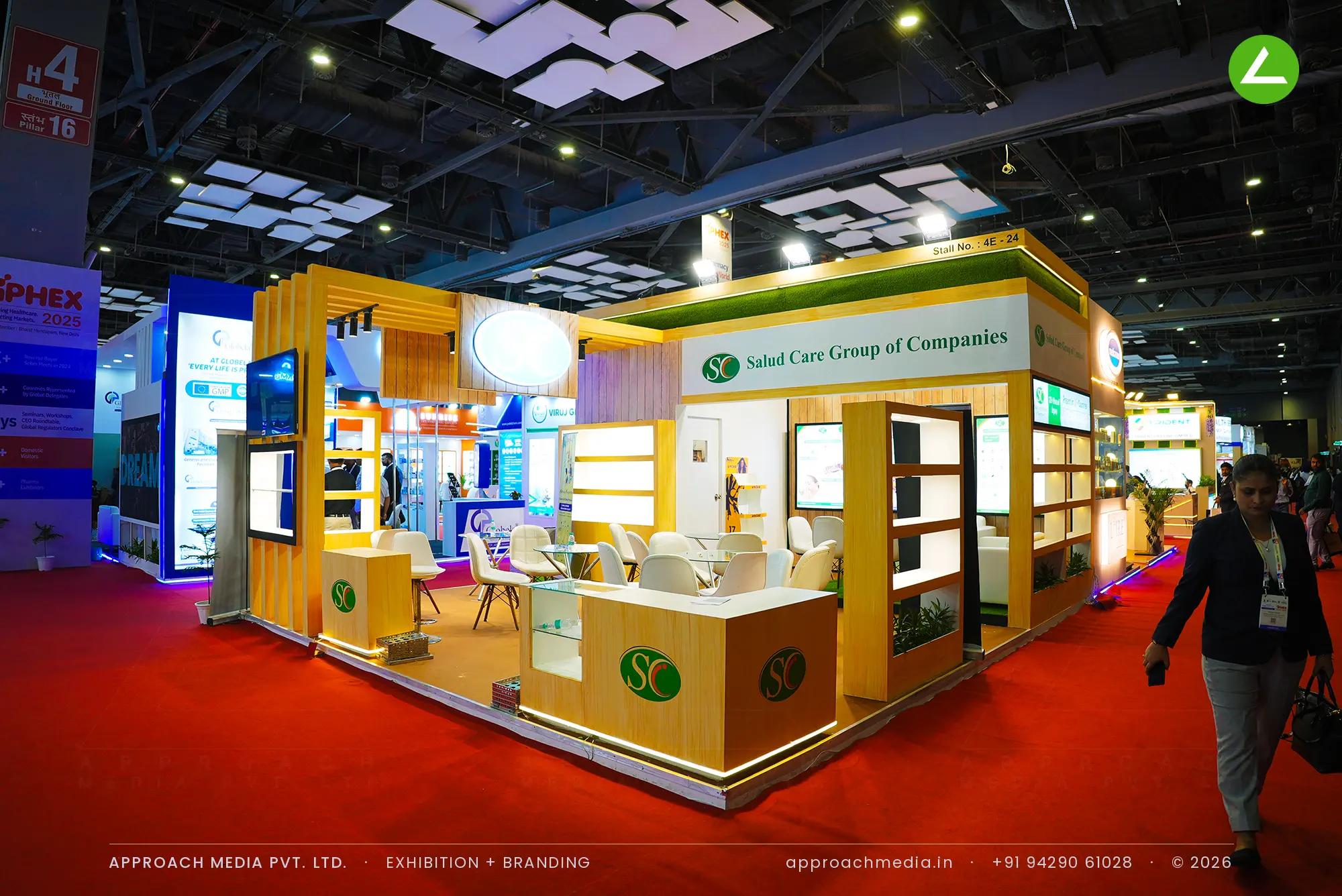 Salud Care exhibition stall design at iPHEX New Delhi with timber batten frames, lit niches and green accents