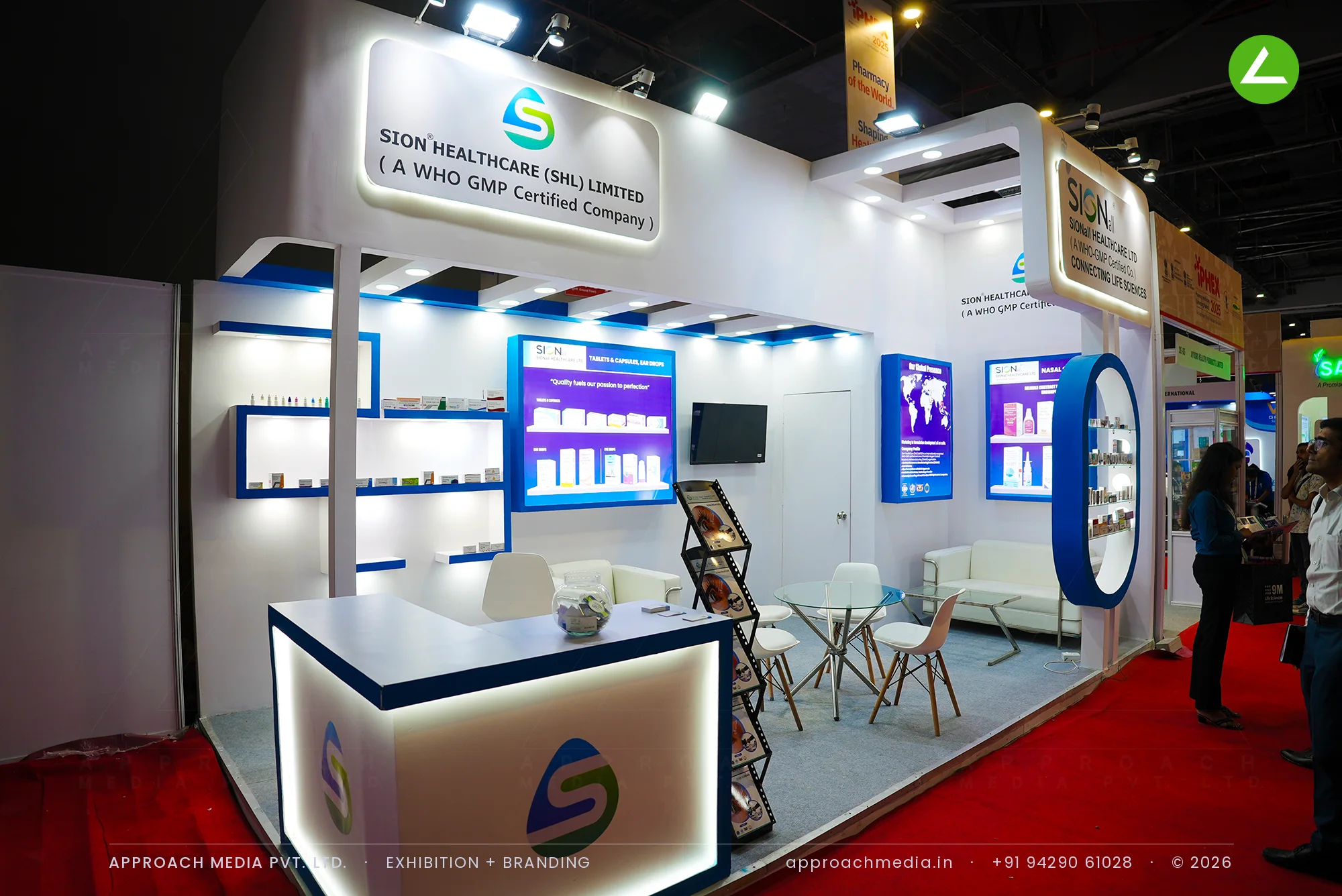 Sion Healthcare exhibition stall design at iPHEX New Delhi with navy floating shelves and a blue oval display frame