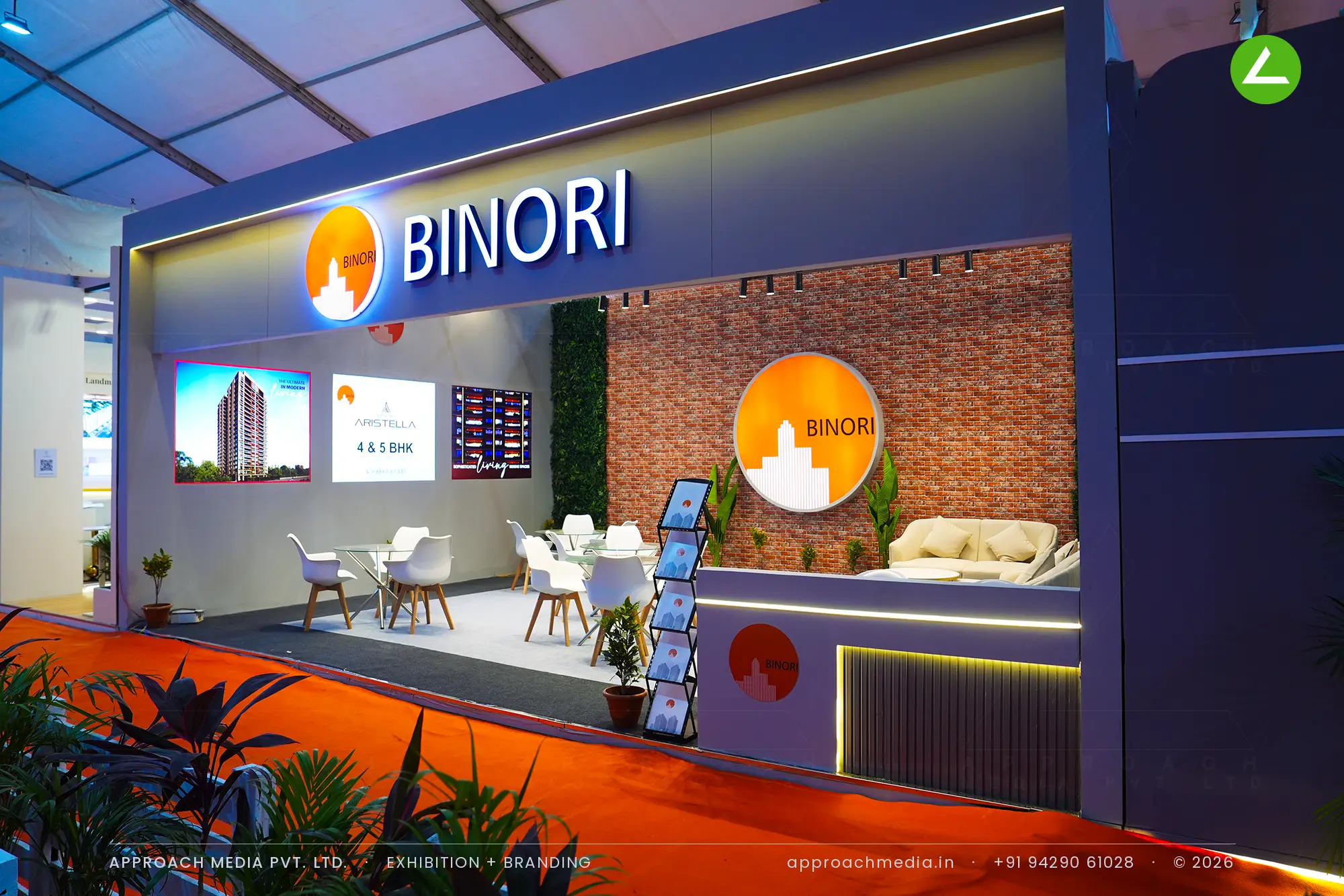 Binori exhibition stall design at NAREDCO Property Expo Ahmedabad with backlit navy fascia and brick lounge wall