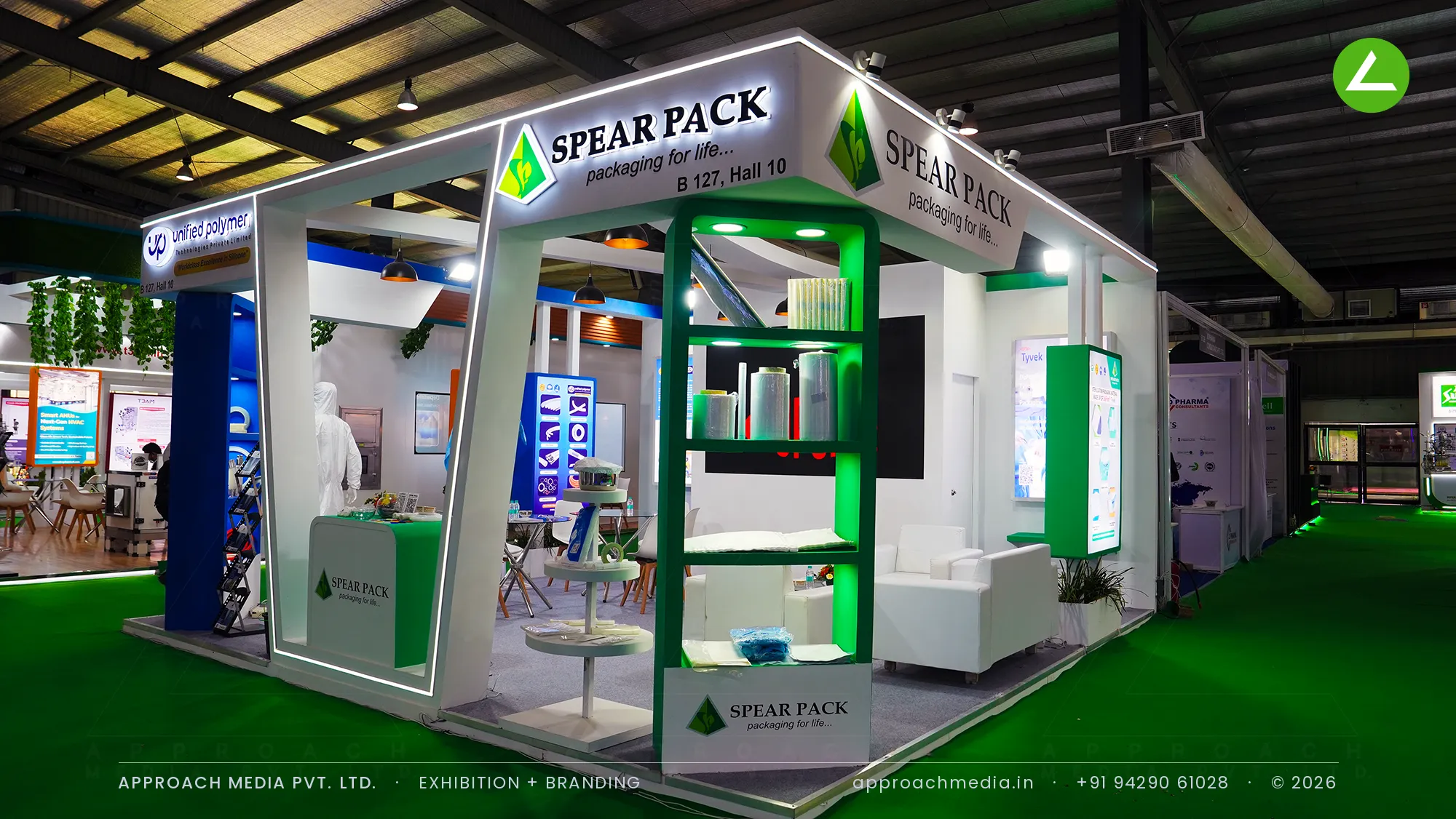 Spear Pack white frame stall with green-lit film roll shelving, exhibition stall design at Pharmatech Expo Gandhinagar