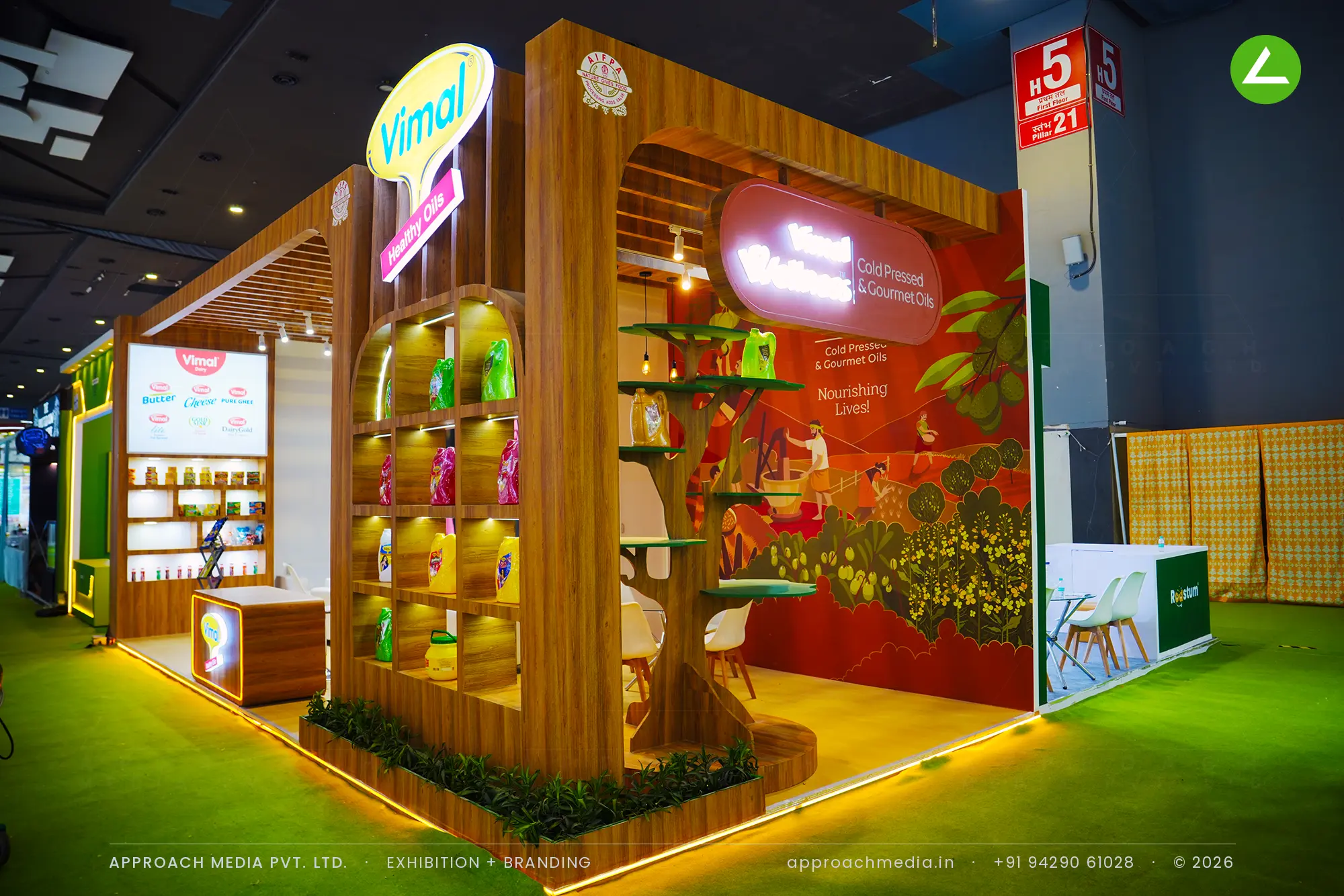 Vimal exhibition stall design at Aahar New Delhi with teak arched niches, a carved display tree and backlit oval signage