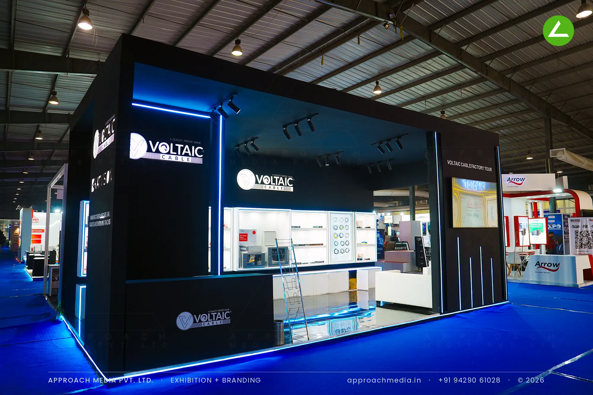 Voltaic Cable exhibition stall design at FITAG Tech Expo Gandhinagar, matte black bay with blue LED lines and lit vitrines