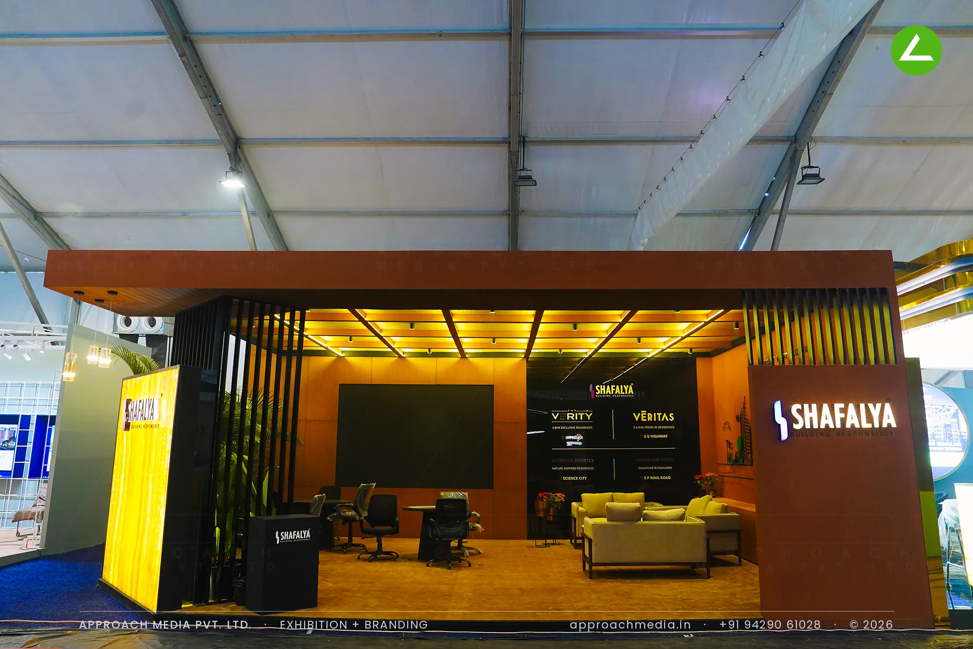 Shafalya exhibition stall design at GIHED Property Show Ahmedabad with rust-brown panelling and a lit coffered ceiling