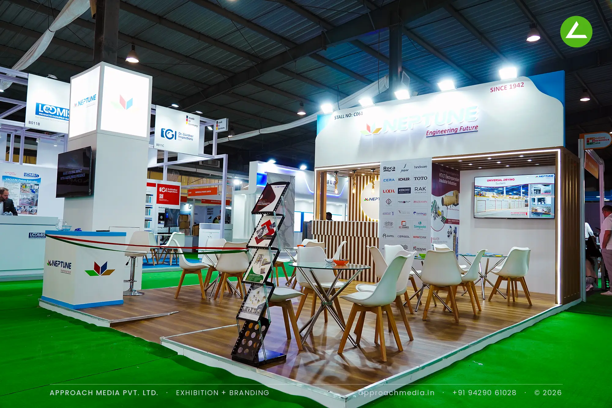 Neptune exhibition stall design at Indian Ceramics Asia Gandhinagar with wood batten wall, halo-lit disc and glass tables