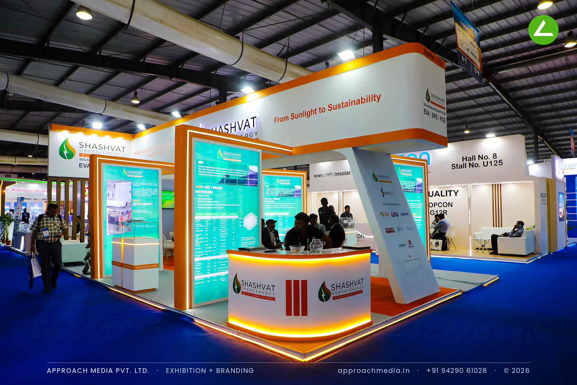 Shashvat Green Energy orange and white exhibition stall design at Intersolar India Gandhinagar with backlit teal panels