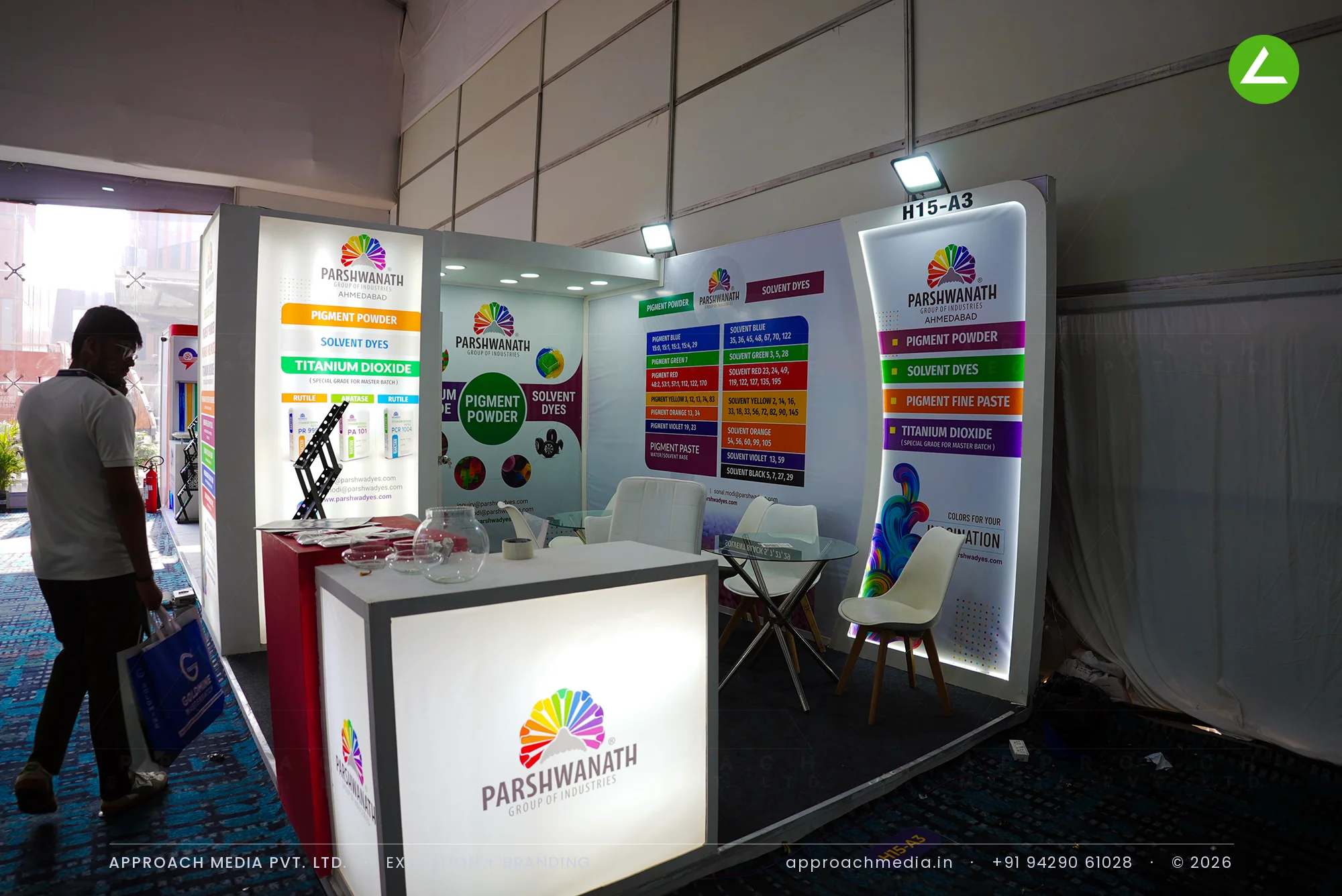 Parshwanath compact exhibition stall design at PlastIndia New Delhi with colour-coded pigment panels and a lit counter
