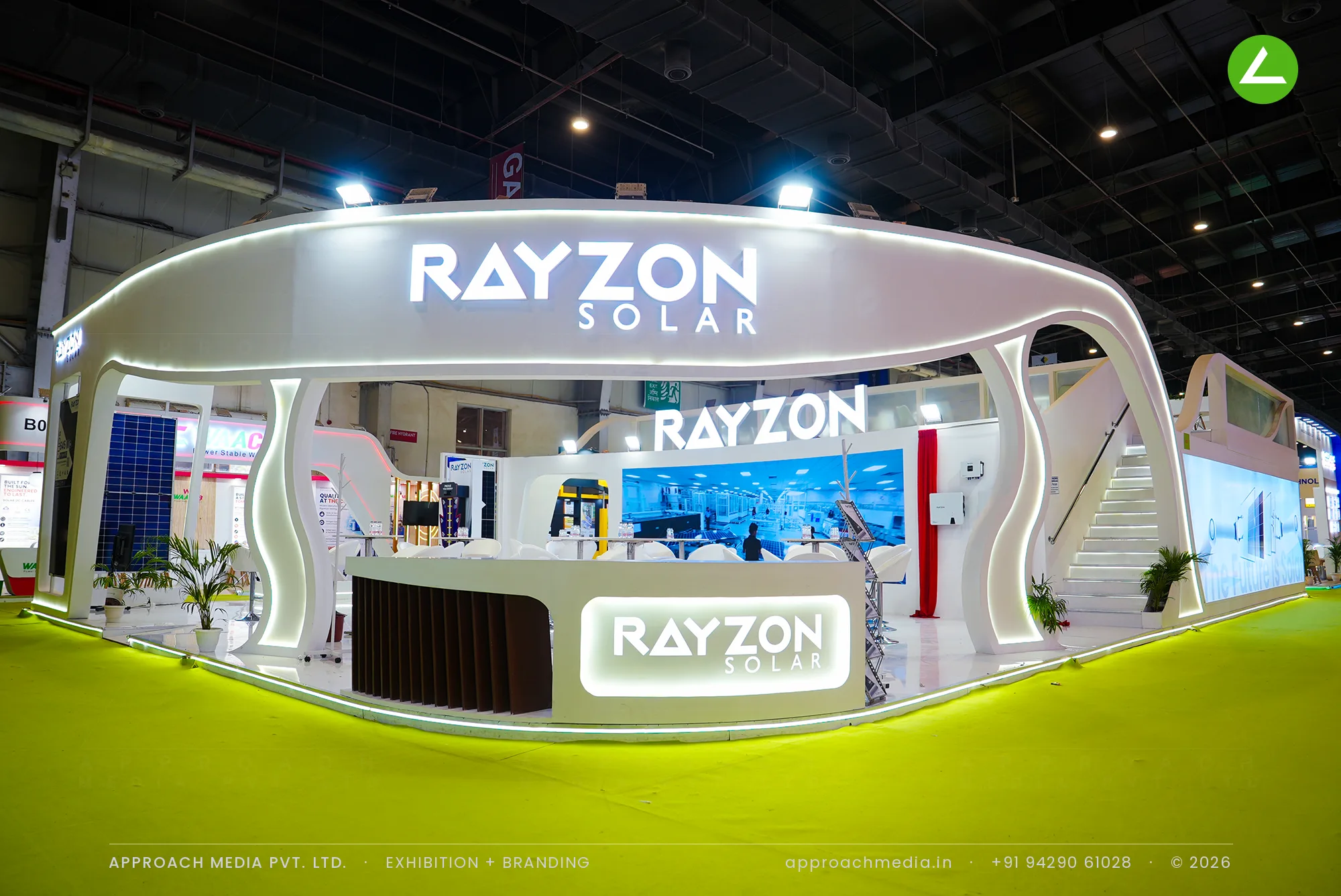 Exhibition stall design at REI Greater Noida: Rayzon Solar curved double-decker island with an oval lit fascia